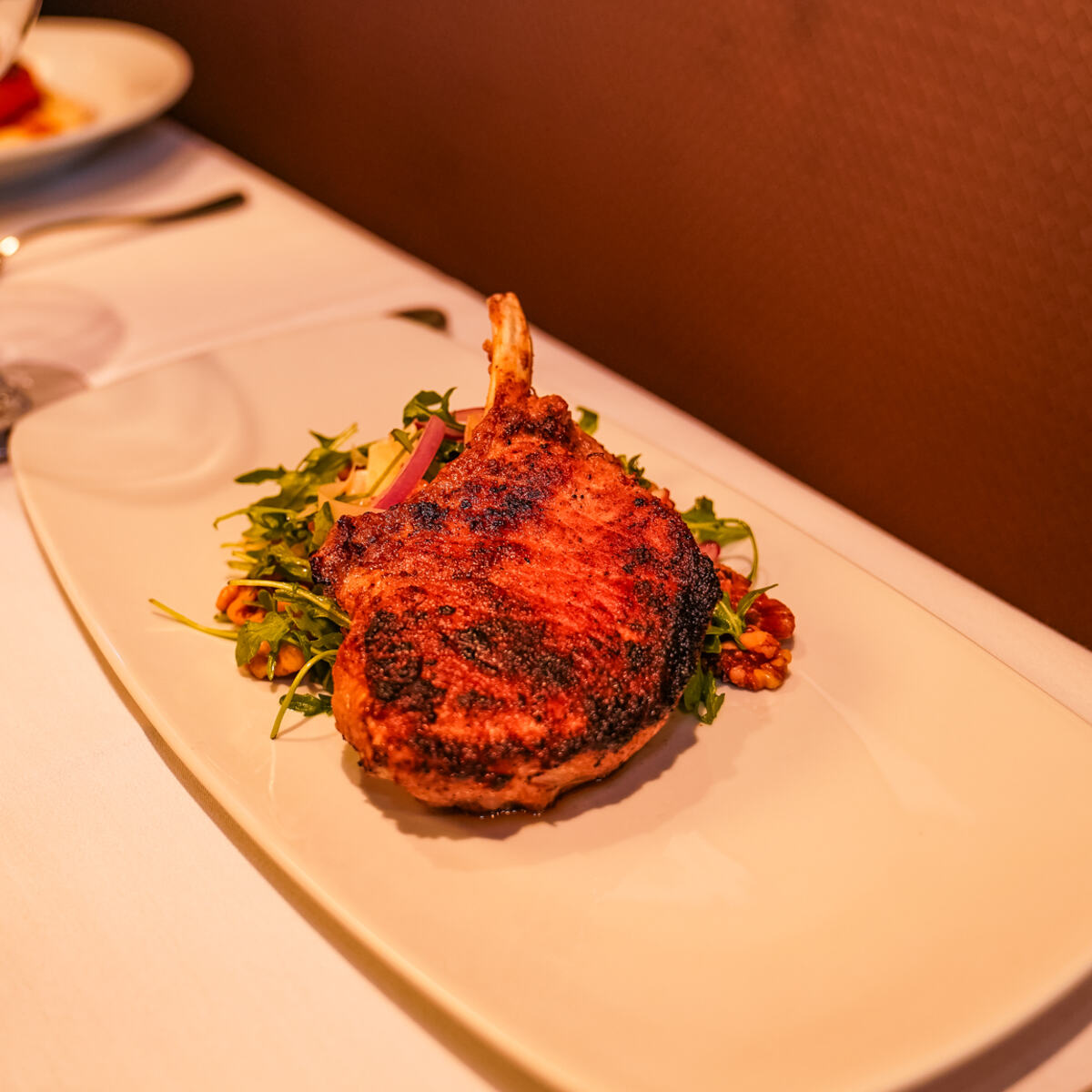 A bone-in cut plated with greens